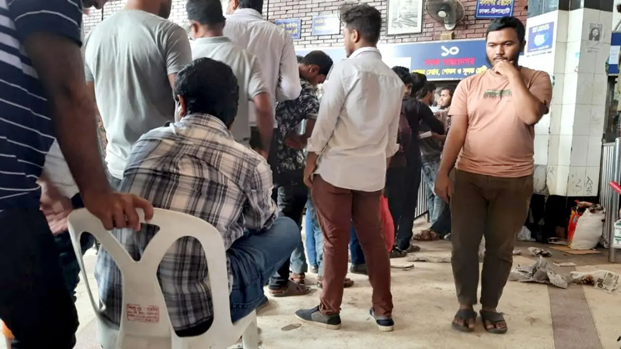 চেয়ারে বসে টিকিটের জন্য অপেক্ষা