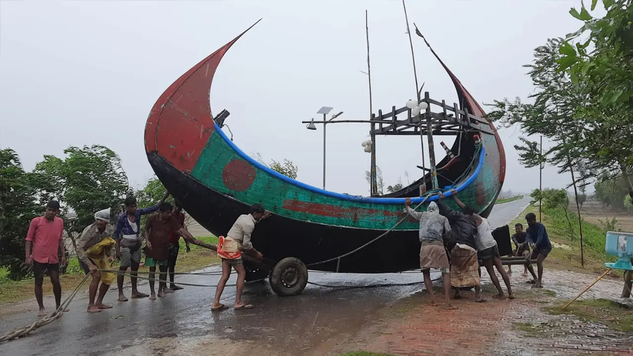 সাগর থেকে সাম্পান সরাচ্ছেন জেলেরা